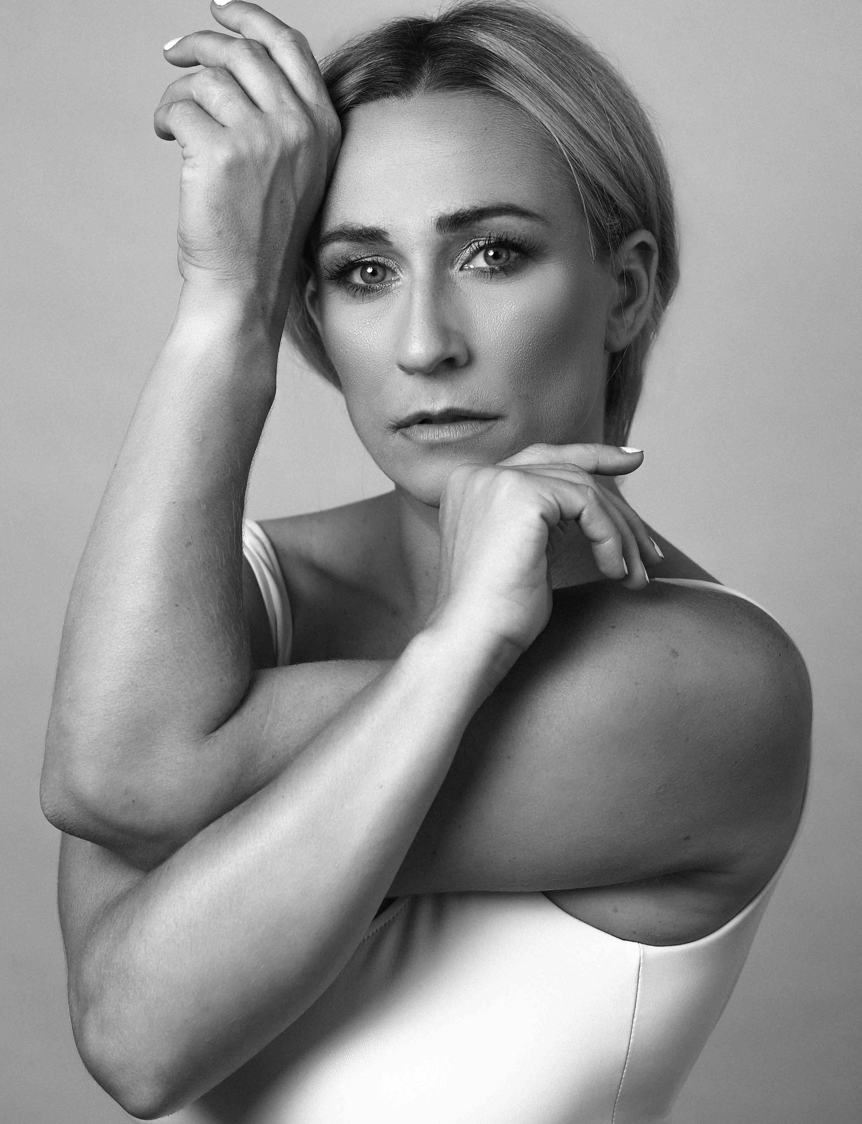 Photo of Taryn Vander Hoop in black and white in front of grey background.